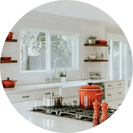 Bright, modern kitchen with red pots on the stovetop and open shelving.
