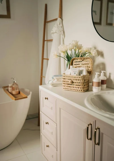 Bathroom with a freestanding tub, white vanity, and a decorative ladder with a towel.