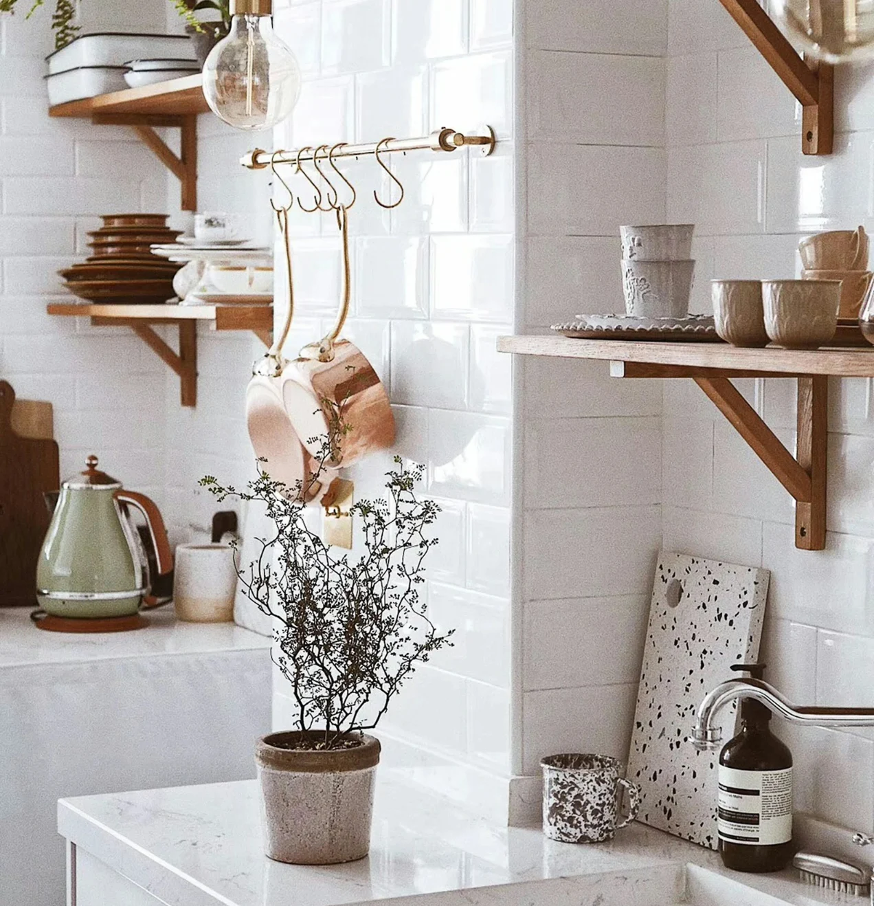 Bright kitchen with open shelving, copper pots, and marble countertops. Kitchen remodeling Ladera Ranch detail.