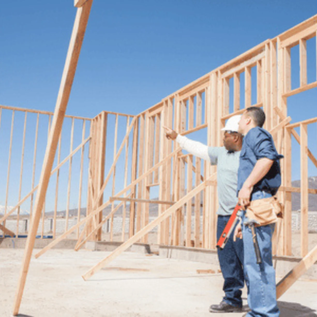 Construction workers inspect new home framing.