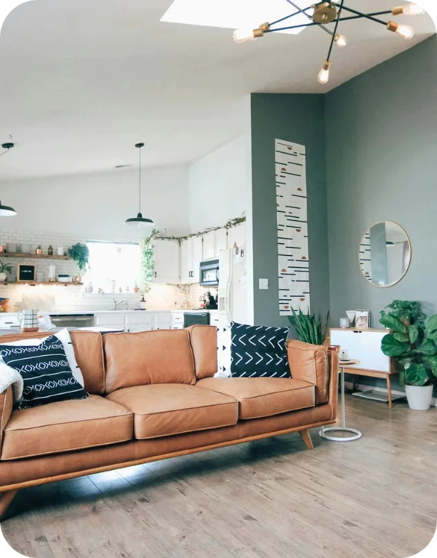 Modern living room with tan leather sofa, open to kitchen.