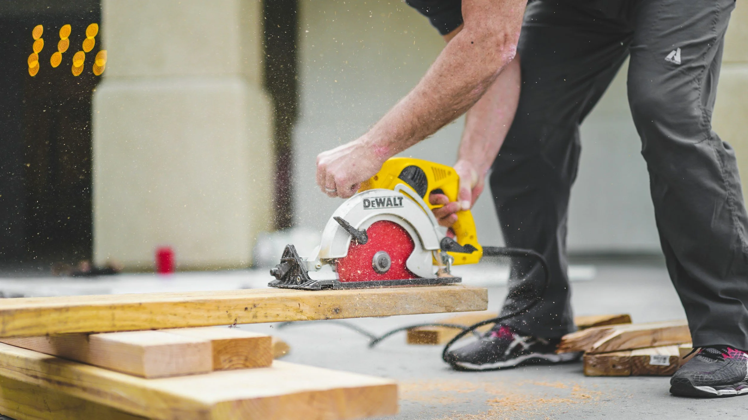 Comprehensive Guide to General Contracting: Local Services, Costs, & Hiring Tips 8 Contractor cutting wood with a DeWalt circular saw.