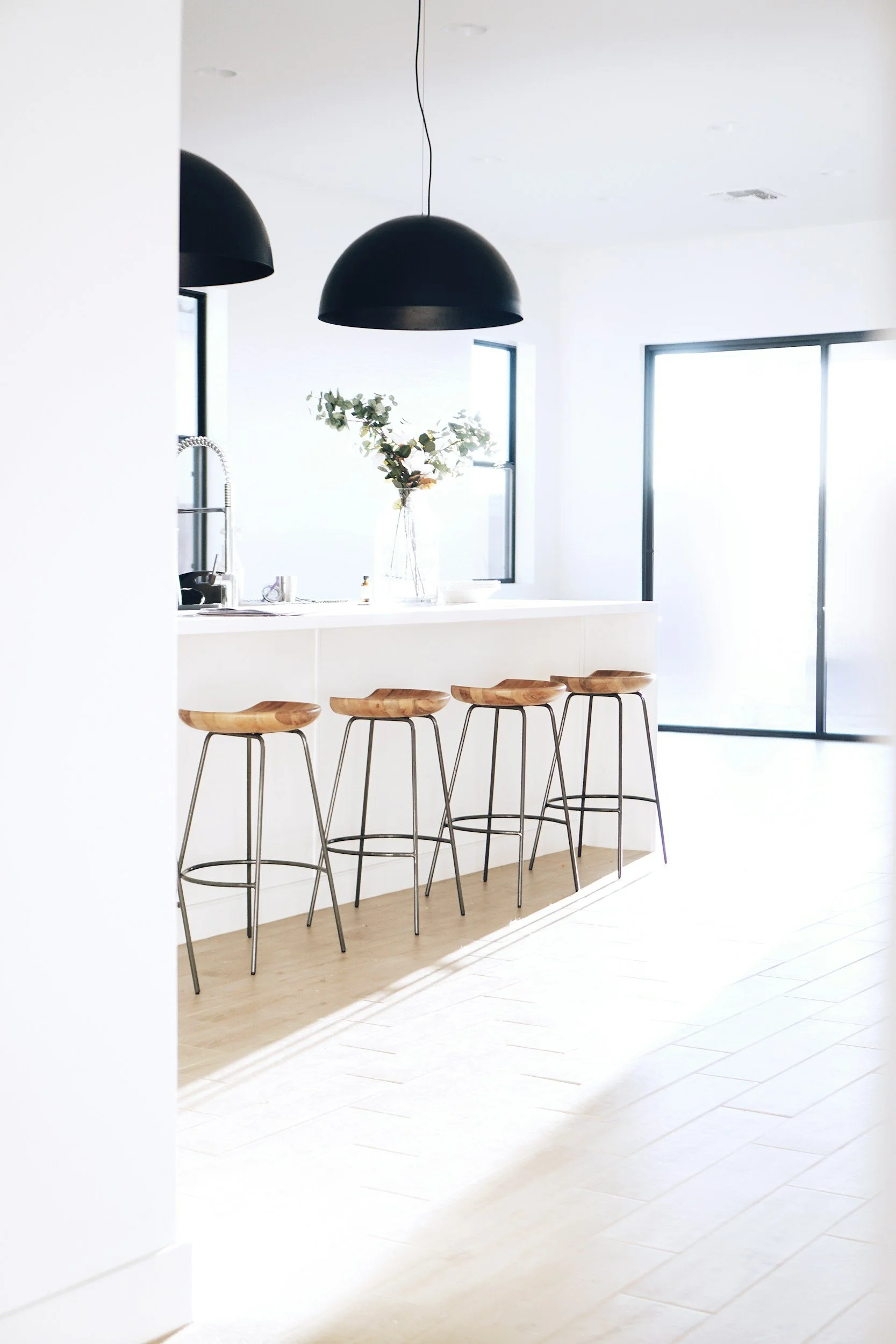 Modern kitchen island with wood stools and black pendant lights. Kitchen Remodeling Laguna Niguel.