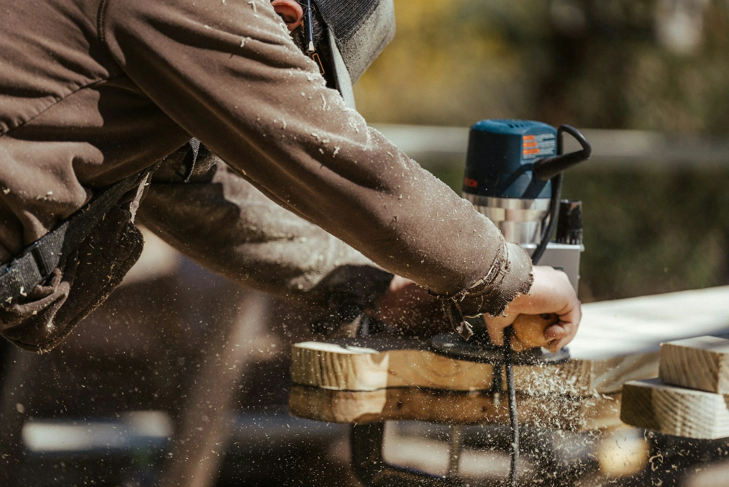 Comprehensive Guide to General Contracting: Local Services, Costs, & Hiring Tips 1 Contractor using a router on wood, creating sawdust. General contracting work.