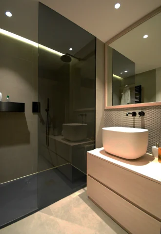 Modern bathroom remodel with a glass shower, vessel sink, and light wood vanity. Part of a Rancho Santa Margarita project.